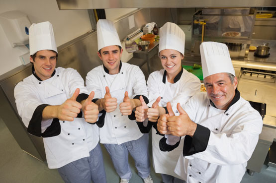 kitchen with happy chefs showing thumbs up